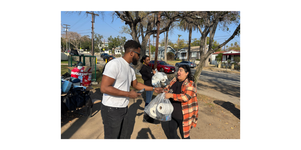 A woman receives a bag of supplies from a church giveaway after the wildfires