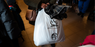 Woman holding bag of donated clothes 